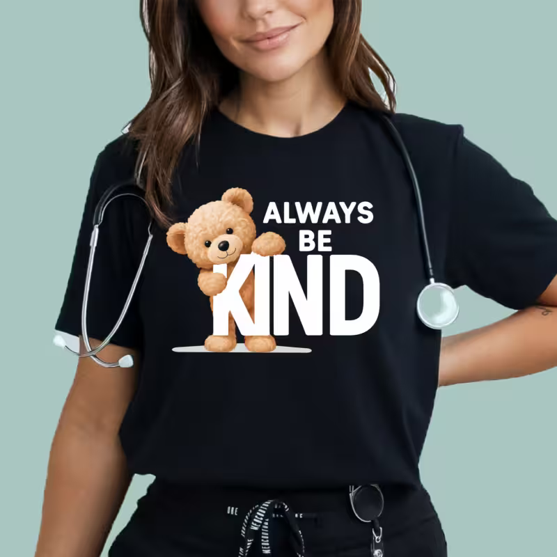 Person wearing a black t-shirt with a teddy bear and 'Always Be Kind' text, holding a stethoscope.