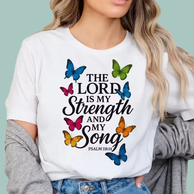 Person wearing a white t-shirt with butterfly design and text on a light blue background