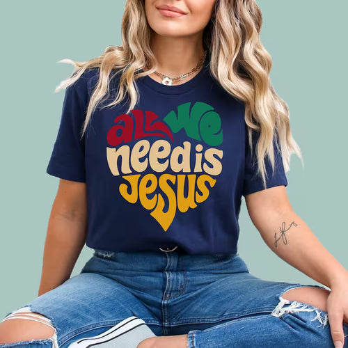 Navy blue minimalist Christian tee with "All We Need Is Jesus" white typography graphic.