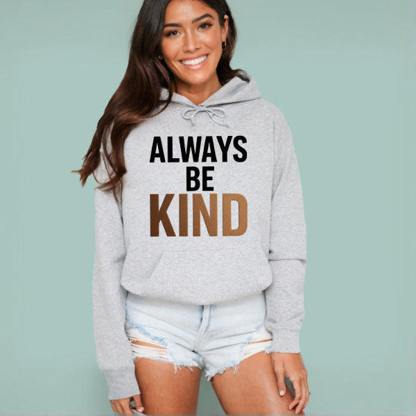 Woman wearing a gray hoodie with 'ALWAYS BE KIND' text on a light blue background