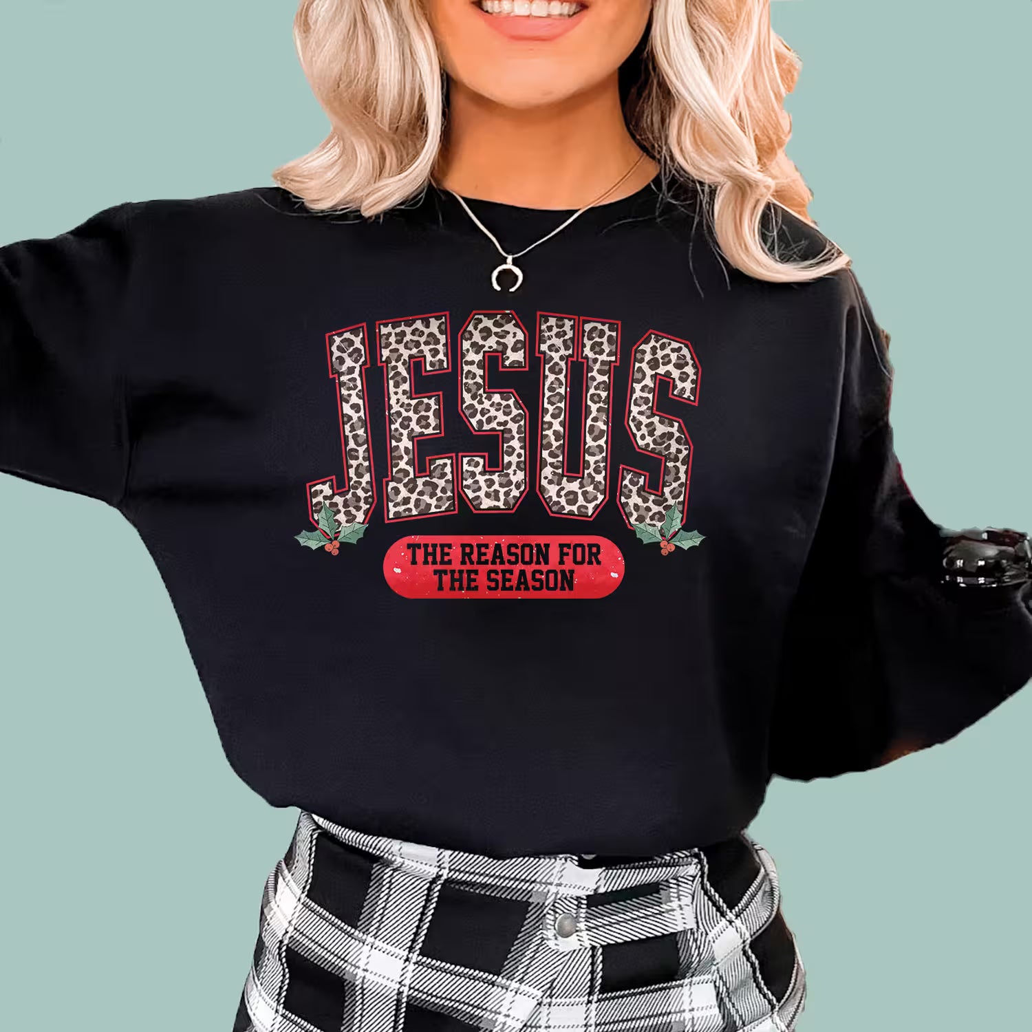 Black faith-based holiday sweatshirt with colorful leopard print Jesus Christmas graphic.