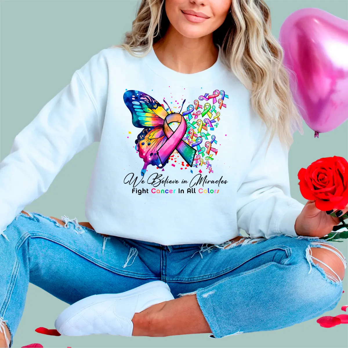 White crewneck sweatshirt with a vibrant multi-colored cancer ribbon graphic and 'Fight Cancer in All Colors' text.