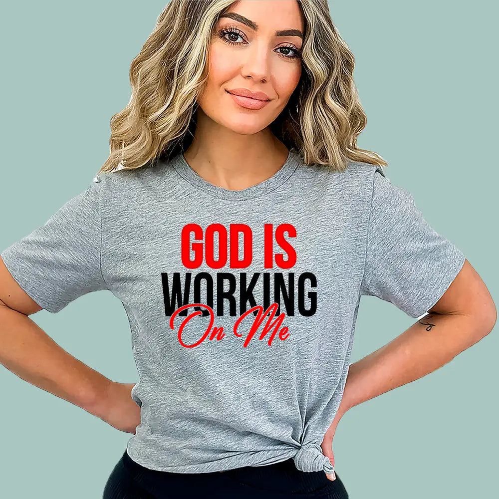 Grey Christian encouragement gift shirt by Alexander Crafts, showing the 'God Is Working On Me' design.