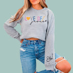 Grey Christian sweatshirt showing the unique heart and cross graphic on the sleeve by Alexander Crafts.