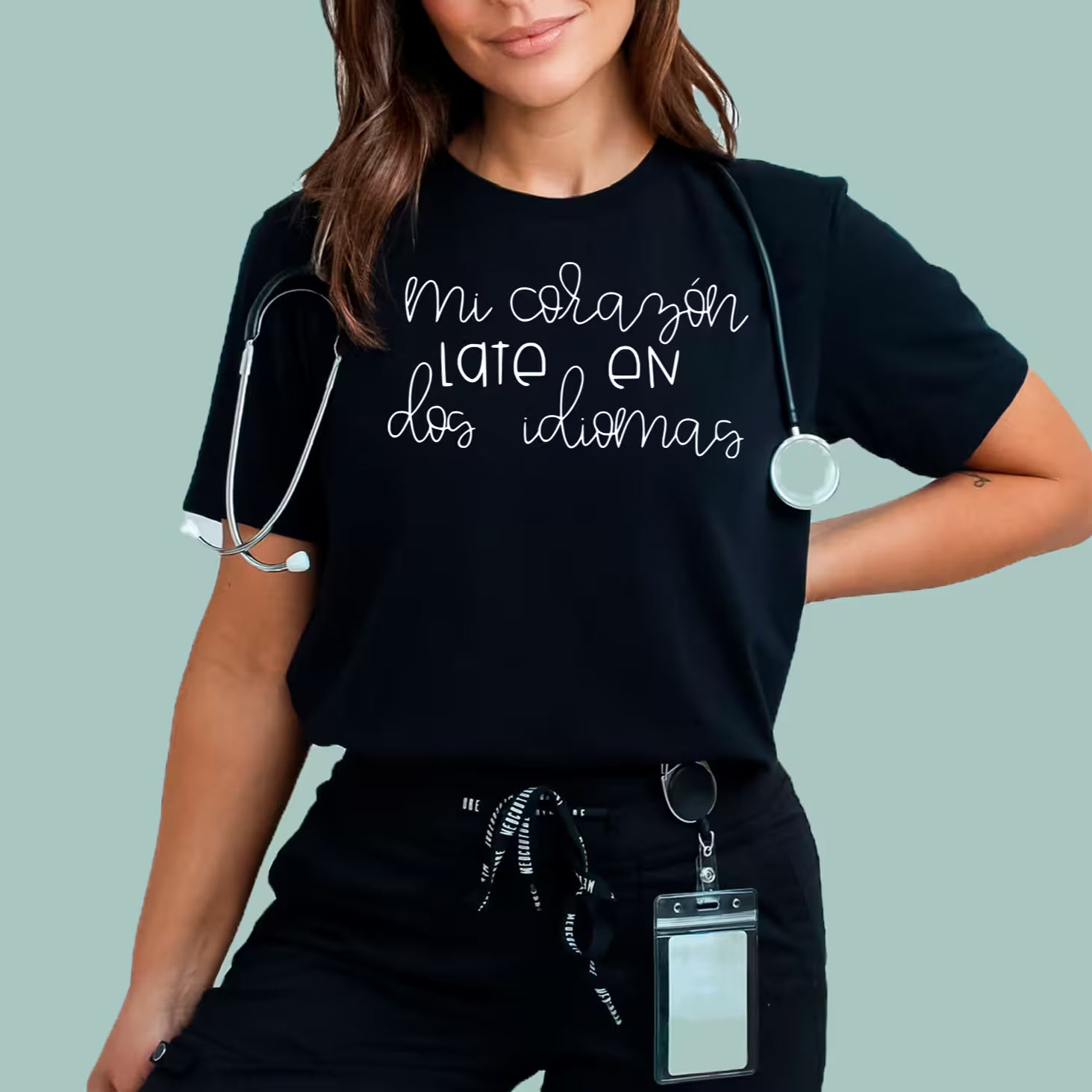 Woman wearing black Mi Corazón Late En Dos Idiomas short-sleeve tee, ideal for Spanish-speaking educators and classroom wear.