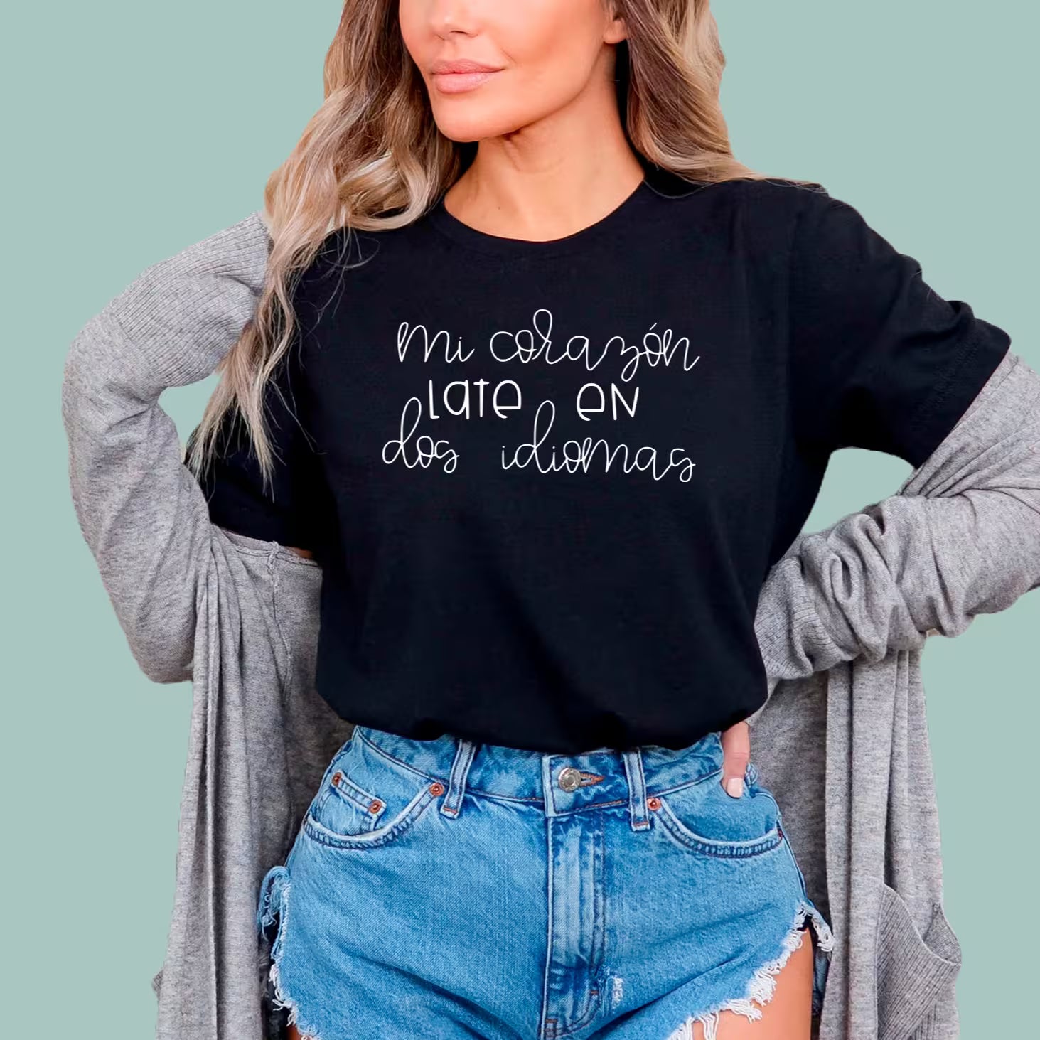 Close-up of black Mi Corazón Late En Dos Idiomas t-shirt showing detailed heart and pencil graphic for bilingual teachers.