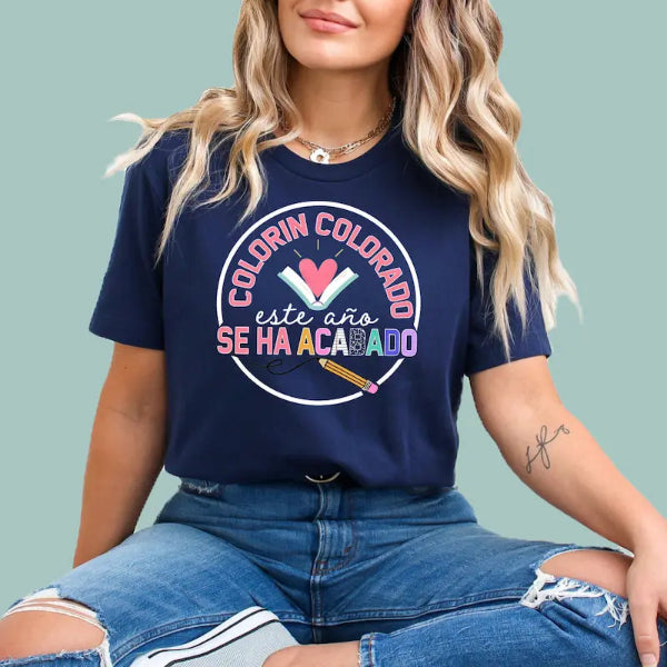 Person wearing a navy blue t-shirt with colorful text end of year and graphics on a light green background