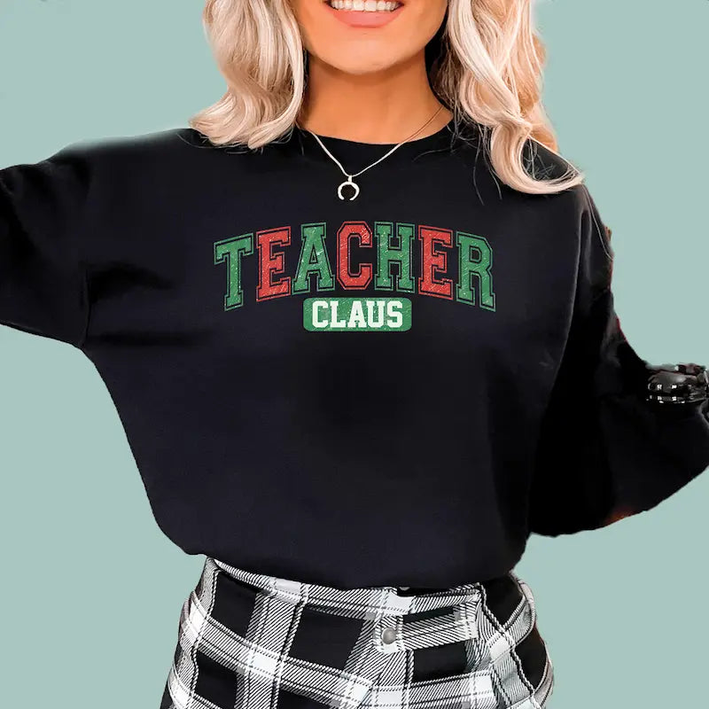 Woman wearing navy Teacher Claus Christmas sweatshirt, a perfect holiday gift for educators.