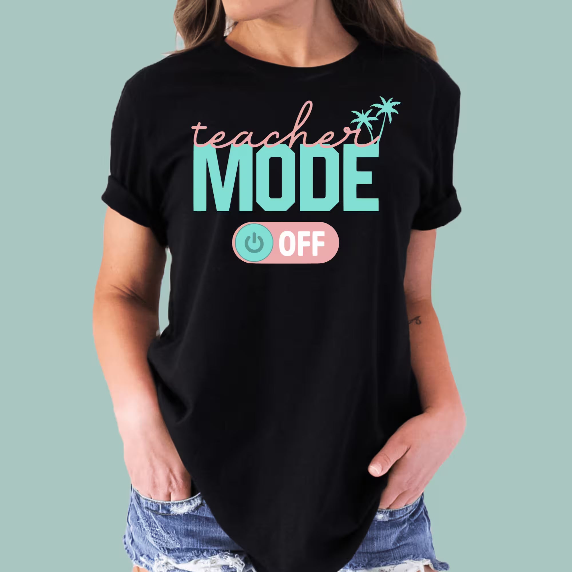 Light blue Teacher Vacation Mode shirt featuring a tropical sun and palm tree graphic.