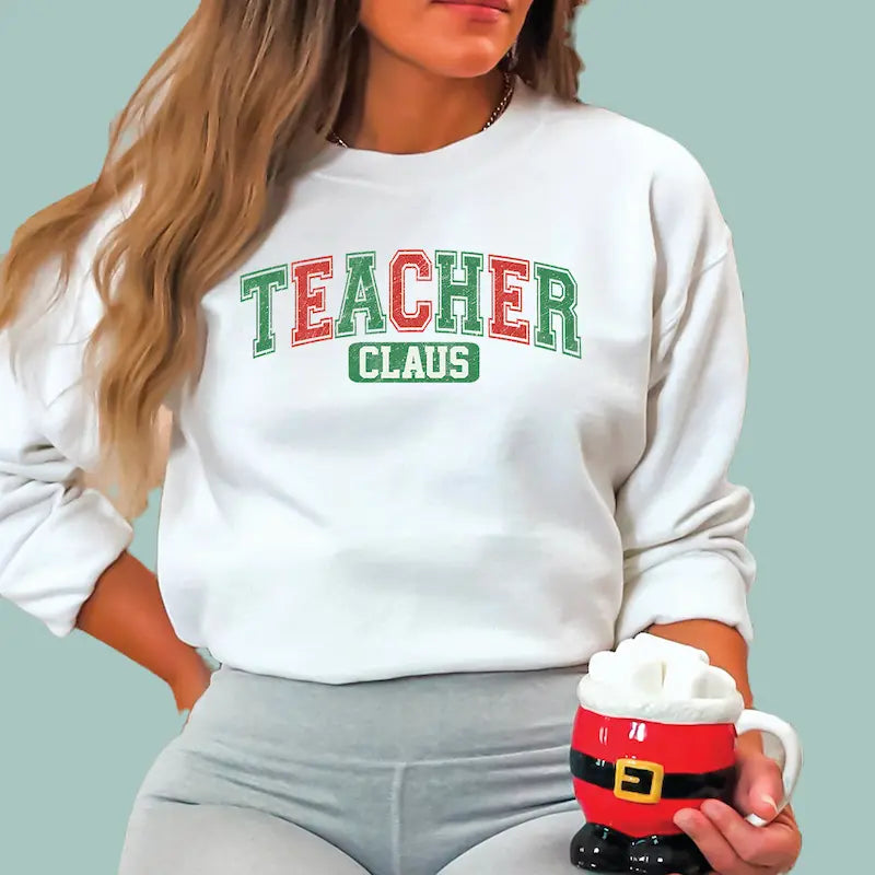 White holiday educator sweatshirt featuring "Teacher Claus" design in classic Christmas colors.