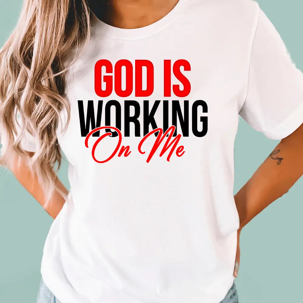 White 'God Is Working On Me' cotton t-shirt, comfortable and high-quality apparel for believers.